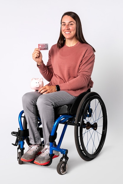 Cool mujer en silla de ruedas mostrando una tarjeta de crédito premium