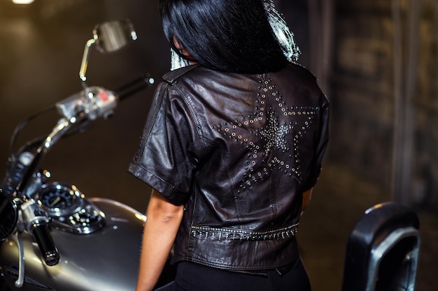 Cool sensual biker girl en una chaqueta de cuero en una motocicleta