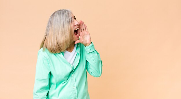 Coole Frau, die laut und wütend schreit, um Platz auf der Seite zu kopieren, mit der Hand neben dem Mund