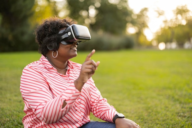 Coole tausendjährige schwarze Frau mit Virtual-Reality-Brille im Outdoor-Park