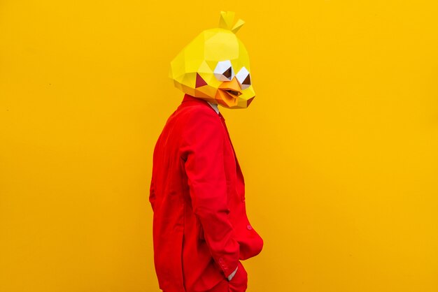 Cooler Mann mit 3D-Origami-Maske mit stilvoller farbiger Kleidung - Kreatives Konzept für Werbung, Tierkopfmaske, die lustige Dinge auf buntem Hintergrund macht
