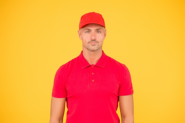 Cooler und stilvoller gelber Hintergrund des Hipsters Gut aussehender Mann im trendigen Hipster-Stil Unrasierter Hipster trägt eine rote Baseballkappe Hipster-Lifestyle Mode und Stil Lässiger Trend