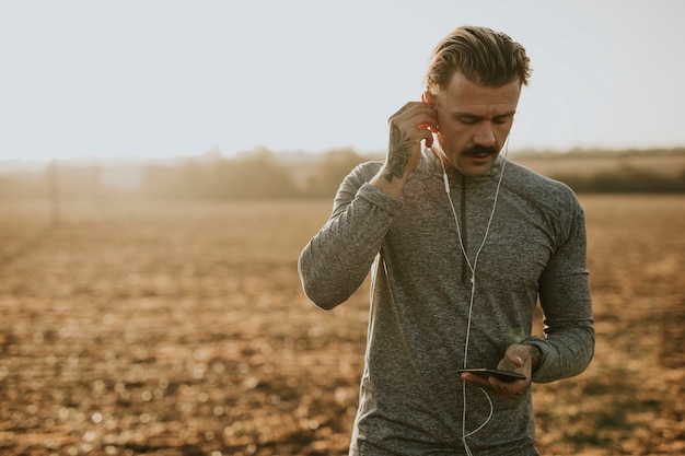 Cooler urbaner Mann, der beim Training Musik hört