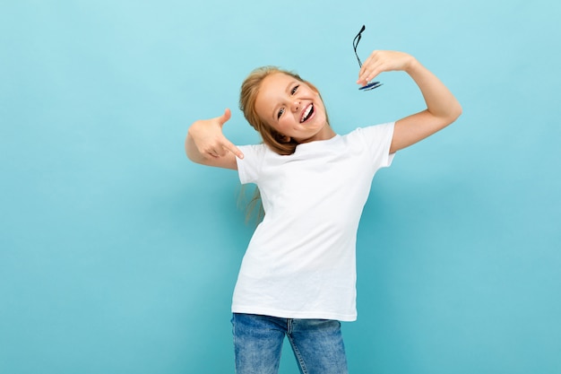 Cooles Mädchen in einem weißen T-Shirt mit Modell auf hellblau