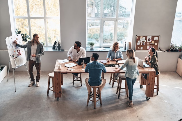 Cooperação em ação. vista superior de um jovem moderno fazendo uma apresentação de negócios enquanto está na sala da diretoria