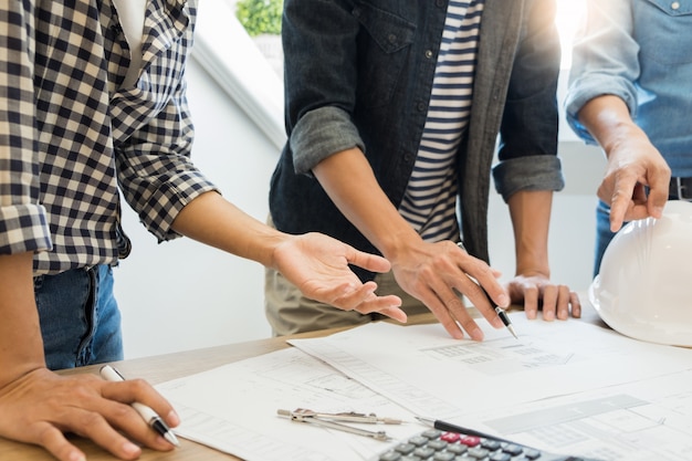 Coordenador que discute a reunião que trabalha no projeto do modelo arquitectónico no canteiro de obras.