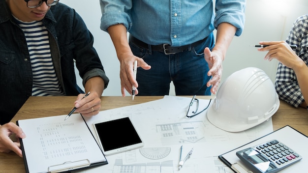 Foto coordenador que discute a reunião que trabalha no projeto do modelo arquitectónico no canteiro de obras.