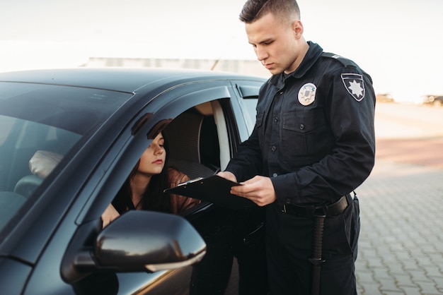 Cop in Uniform prüft Führerschein der Fahrerin