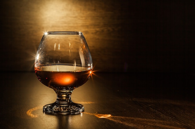 Una copa de brandy en la mesa de madera.