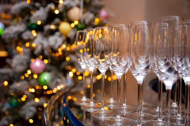 Una copa de champán en el fondo de un árbol de Navidad decorado