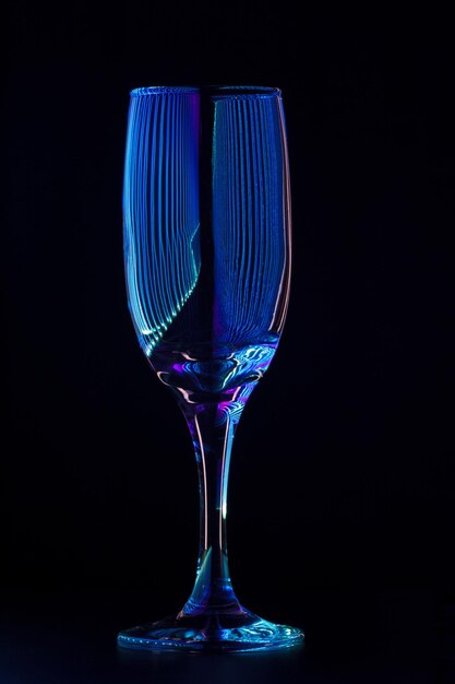 Foto copa de champán con reflejo de rayos de luz de colores