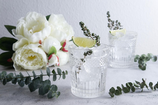 Copa de cóctel facetada con hielo picado y limón en el primer plano de la mesa