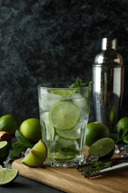 Copa de cóctel mojito e ingredientes contra un fondo ahumado oscuro