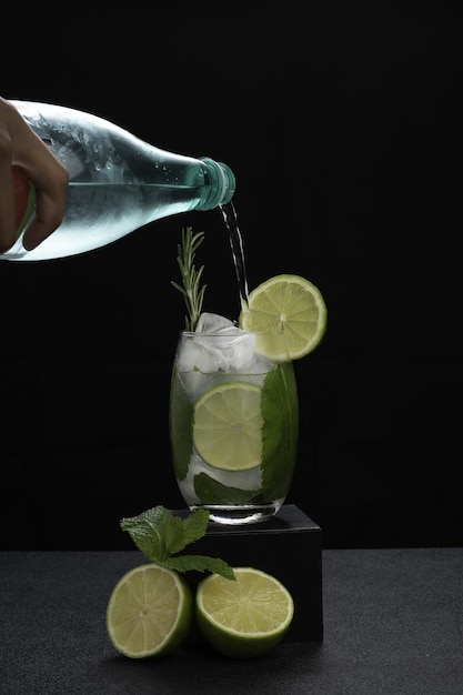 una copa de cóctel mojito sobre un fondo oscuro