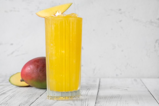 Copa de cóctel de ponche de mango aderezado con una rodaja de mango