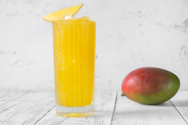 Copa de cóctel de ponche de mango aderezado con una rodaja de mango