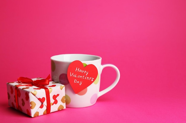 Copa com cartão e caixa de presente para dia dos namorados em fundo rosa