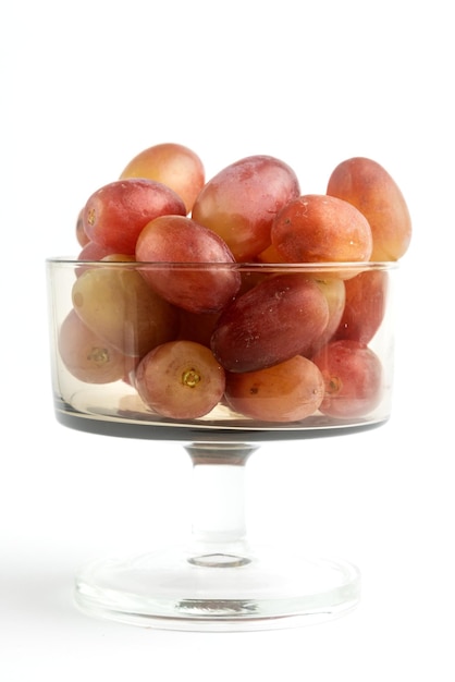 Copa de cristal con uvas rojas.