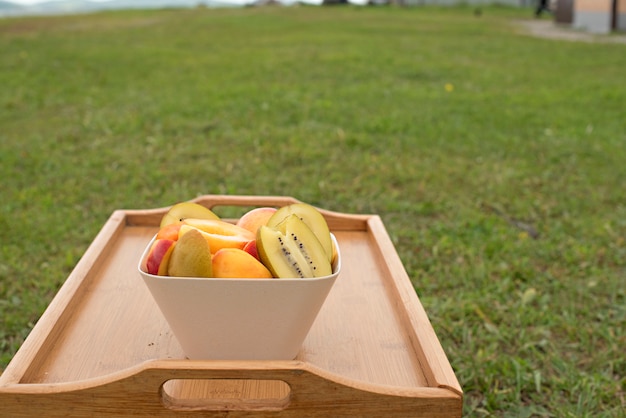 Copa de frutas fica em uma mesa de madeira.