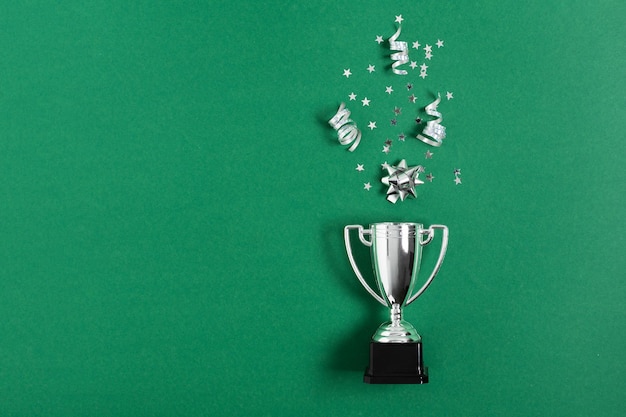 Copa do troféu de prata vencedor ou campeão com confete em fundo verde Conceito de vitória ou sucesso