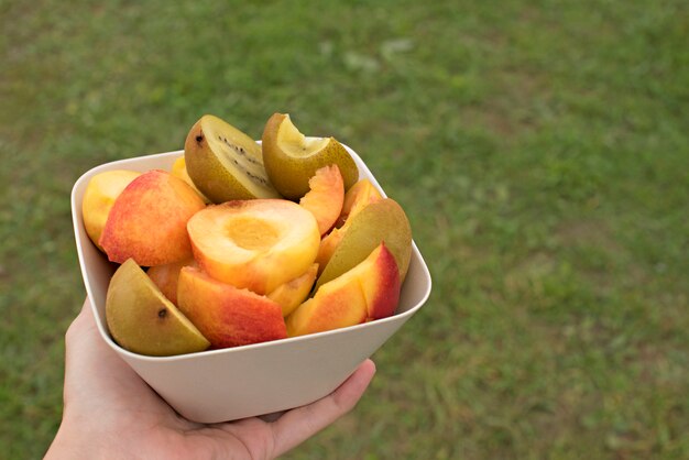 Copa de la fruta se encuentra en una mesa de madera.