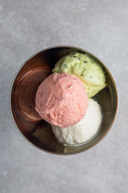 Copa de hielo italiana y comida con vista superior Sabores de helado en taza sobre fondo gris