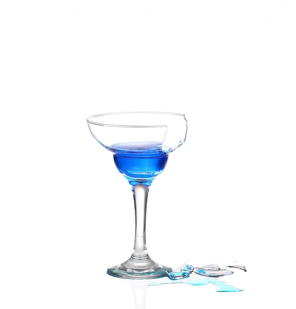 Copa de martini con agua azul y cristales rotos