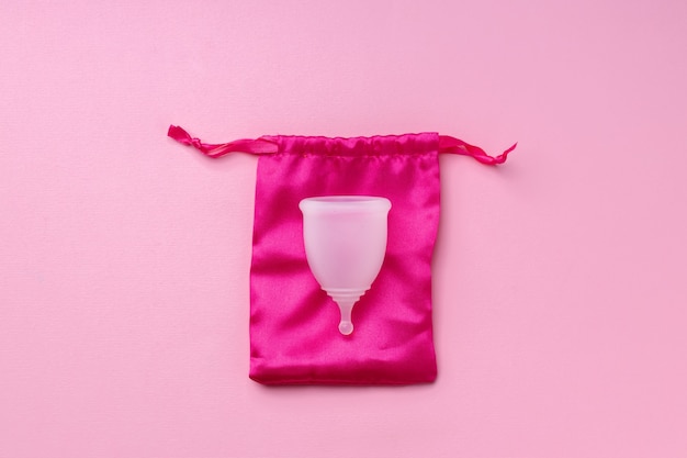 Foto copa menstrual blanca en vista superior rosa