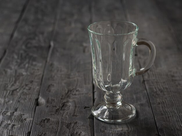 Copa de vidrio con asa sobre mesa de madera