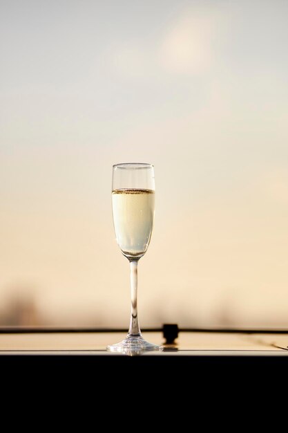 Una copa de vino blanco contra el cielo del atardecer