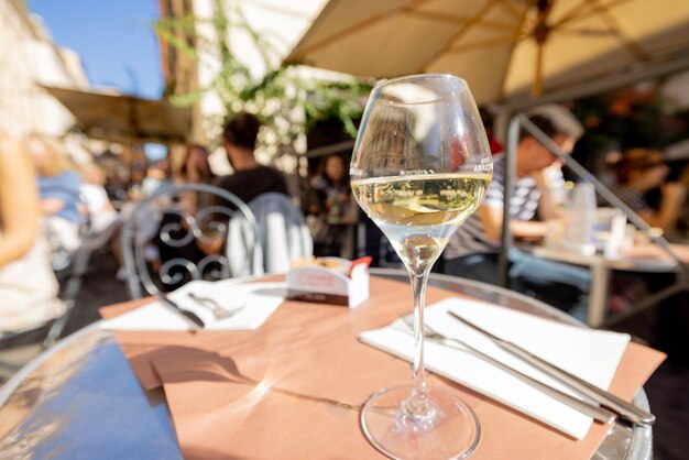 Copa de vino blanco en una mesa de restaurante al aire libre