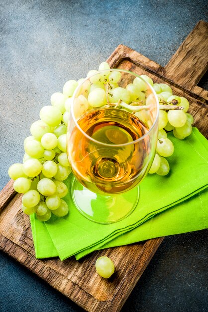 Copa de vino blanco con una rama de uvas