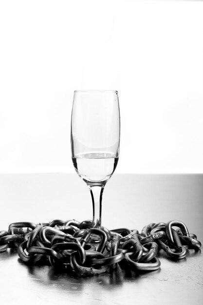 Copa de vino con cadenas sobre fondo blanco.