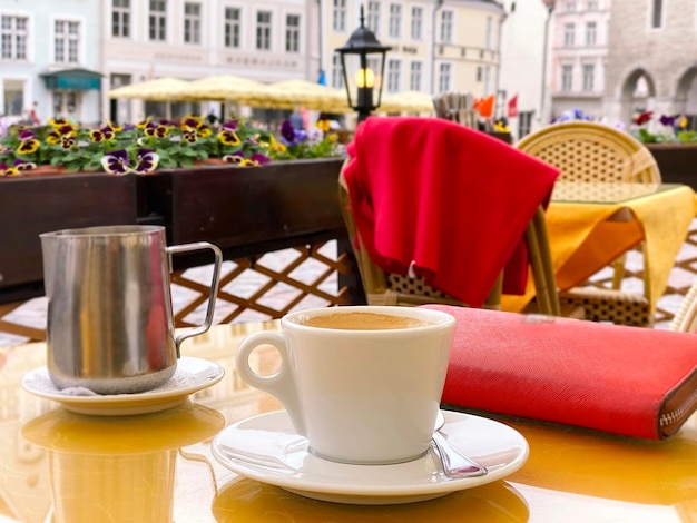 Copa de vino y café en la mesa de café de la calle en el casco antiguo de Tallin