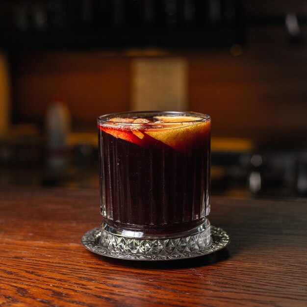 Copa de vino caliente caliente tradicional con rodajas de naranja servido en la mesa en el café