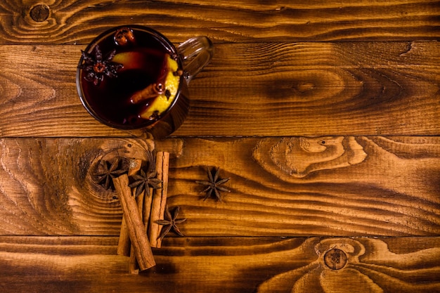 Copa de vino caliente con canela en la mesa de madera Vista superior