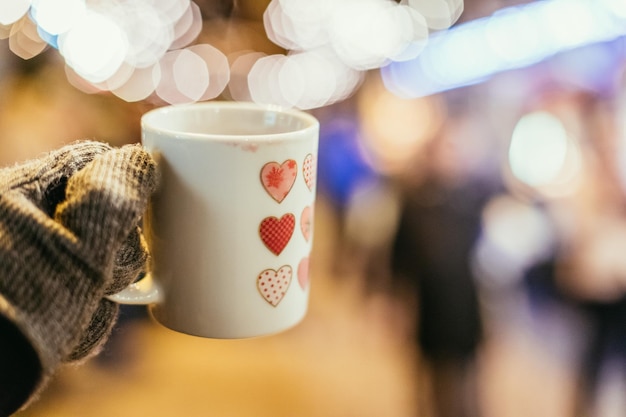 Copa con vino caliente en el espacio de copia del mercado navideño