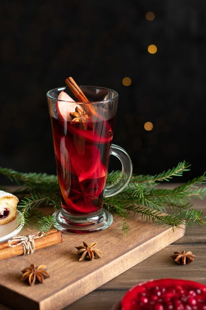 Una copa de vino caliente navideño con especias y pasteles de bayas