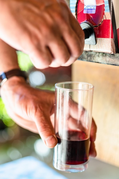 Copa de vino cerca del grifo de las cajas de vino al aire libre