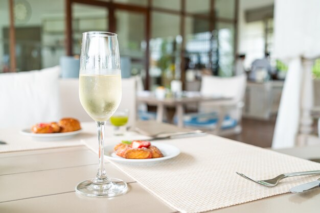 Copa de vino espumoso en la mesa en la cafetería restaurante