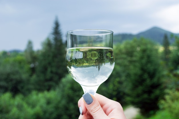 Una copa de vino con una imagen invertida en la mano de la niña.