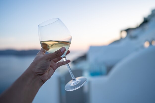 Una copa de vino en la mano.