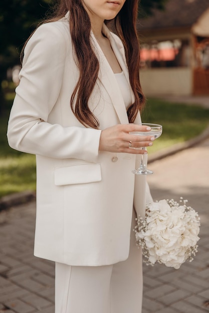 La copa de vino en manos de una chica con vestido informal blanco