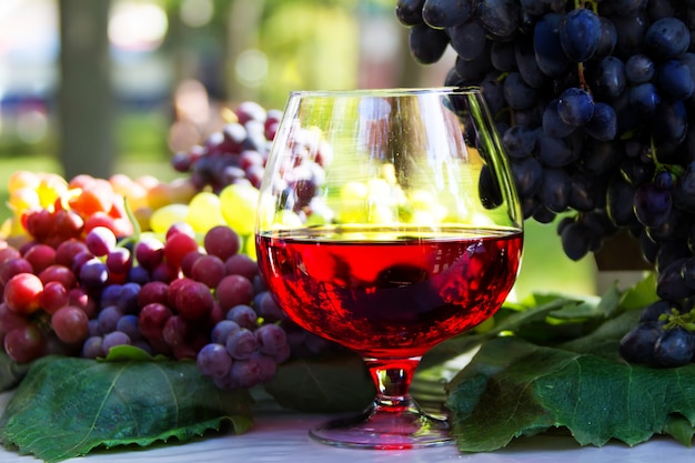 Una copa de vino y un racimo de uvas. Vino tinto en un vaso