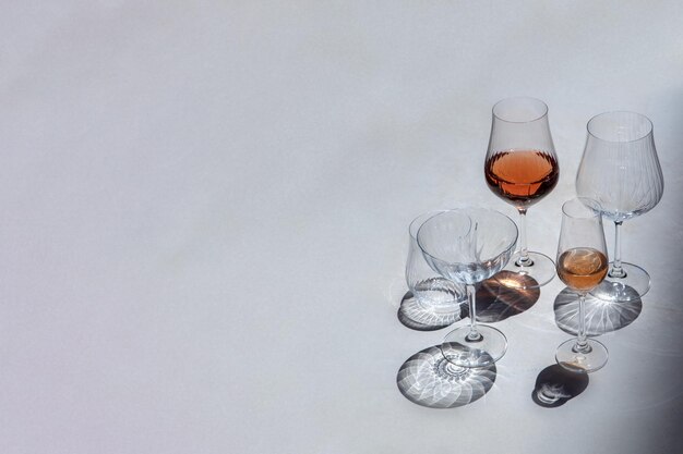 Copa de vino sobre un fondo de hormigón con sombras contrastantes con espacio de copia