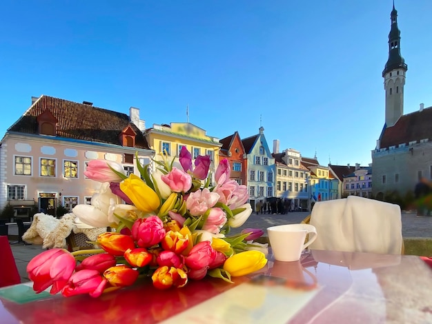 Copa de vino y taza de café y velas en la mesa de café de la calle en la ciudad medieval del casco antiguo de Tallin