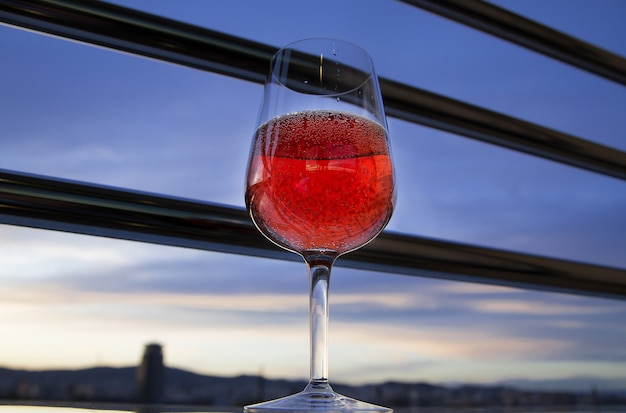 copa de vino tinto en el balcón por la noche