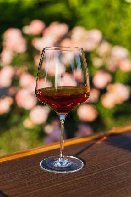 Una copa de vino tinto contra el fondo del jardín al aire libre