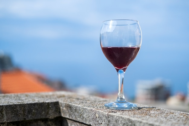 Una copa de vino tinto frío en el balcón contra