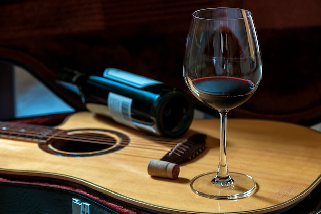 Copa de vino tinto en la guitarra acústica